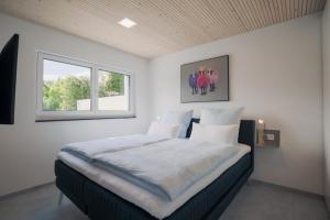 OwingenPurer Genuss - Garten und Alpe的一间卧室设有一张大床和两个窗户