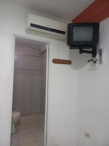 曼塔Hostal Continental的一间带卫生间的浴室和墙上的电视