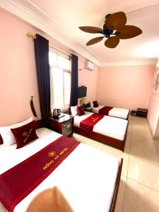Thach LoiHong Ha Airport Hotel的酒店客房配有两张床和吊扇。