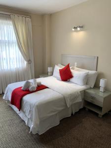 温特和克图勒酒店的一间卧室配有一张带红色和白色枕头的大床