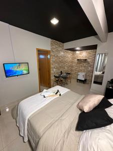 巴西利亚Riacho HOTEL的一间卧室设有两张床,墙上配有电视。