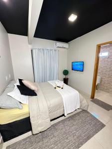 巴西利亚Riacho HOTEL的一间带大床和电视的卧室