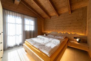 维尔德豪斯Chalet Gamserrugg的卧室配有木墙内的一张床