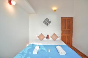 安君纳Villa Seafront Goa的一间卧室配有蓝色的床、白色床单和枕头