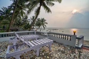 安君纳Villa Seafront Goa的坐在海边的白色长椅