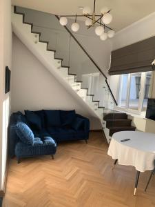 考纳斯Kaunas Embassy Apartments的客厅设有蓝色的沙发和楼梯。