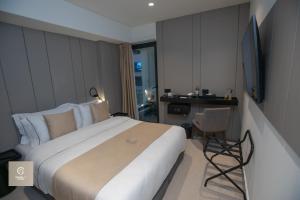 地拉那Central Inn Hotel的酒店客房设有一张大床和一张书桌。