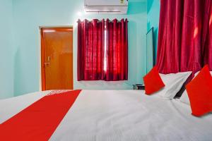 那格浦尔OYO Hotel R R的一间卧室配有一张带红色窗帘的大床