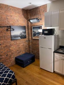 纽约Midtown Nest 1 bedroom Self Serviced Apartment的厨房配有白色冰箱和砖墙
