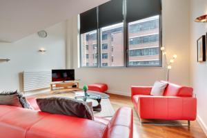 泰恩河畔纽卡斯尔Crown Apartments 104 by Week2Week的客厅配有2张红色沙发和电视