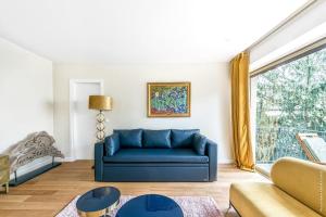布洛涅-比扬古Boulogne Billancourt - Schuman 1bdr的客厅设有蓝色沙发,配有窗户