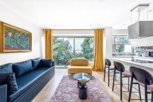布洛涅-比扬古Boulogne Billancourt - Schuman 1bdr的一间带蓝色沙发的客厅和一间厨房