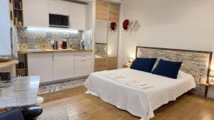 瓦朗斯Le studio d'Agathe centre historique - Confort & Calme的一间卧室配有一张带蓝色枕头的大床