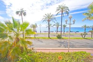 尼斯Promenade des Anglais - Sea View 2bdr的一条棕榈树和大海的街道