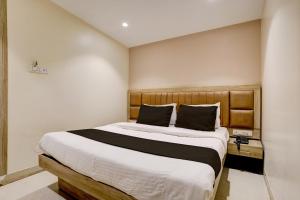 孟买Hotel Al Ibrahim的一间卧室配有一张大床和木制床头板