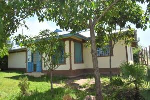 MarindeThe D'Lux Home, Homa Bay的蓝色窗户和树的房子