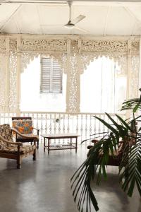 桑给巴尔Balcony House的配有椅子和桌子的房间,窗户