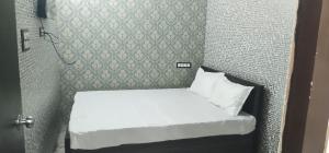 kolkataHOTEL BLUE MOON的一张小床,位于一个小房间里,墙上