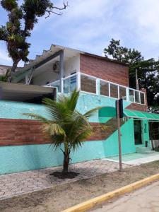 佩鲁伊比CASA DO PESCADOR的前面有棕榈树的房子