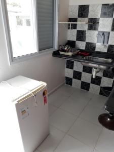 佩鲁伊比CASA DO PESCADOR的厨房配有白色冰箱和黑白瓷砖
