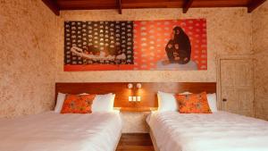 弗洛勒斯Macarena Hostel的一间卧室设有两张床,墙上挂着一幅画