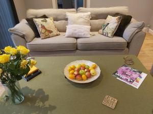 雷利Rose Garden Retreat的客厅配有带一碗水果的桌子