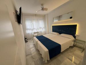 加的斯伊马尔旅馆的一间卧室配有一张带蓝白色毯子的床