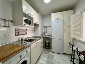 加的斯艺玛图瑞斯提科公寓酒店的白色的厨房配有水槽和冰箱
