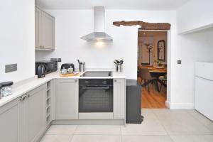 桑德巴奇Chapel House, Where Comfort Meets Convenience - BOOK NOW!的白色的厨房设有水槽和炉灶。