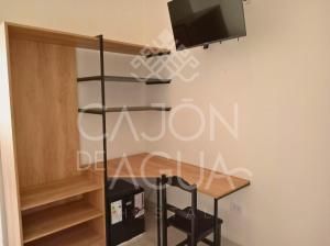 卡法亚特Cajón de Agua的一间设有桌子的房间和墙上的电视