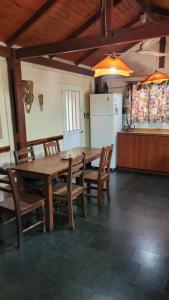 圣罗莎卡拉穆奇塔县Hakuna Matata的厨房配有木桌、椅子和冰箱。