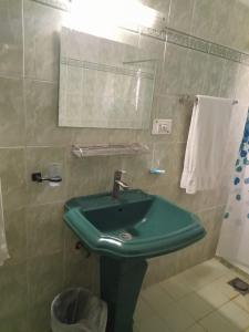 伊斯兰堡Cape Town Guest House的一间带绿色水槽和毛巾的浴室