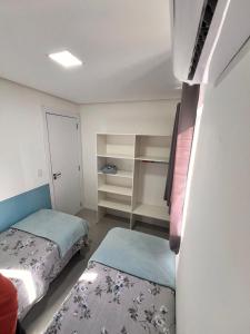 弗洛里亚诺波利斯Los Hermanos Residencial的小房间设有两张床和一个衣柜