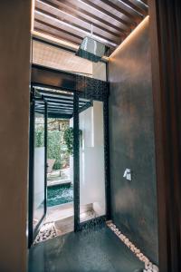 VillarrealEpic Tamarindo Boutique Hotel的浴室设有通往庭院的玻璃门