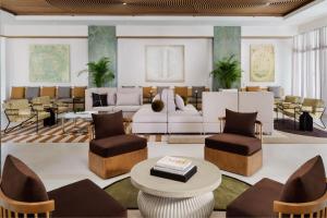 那不勒斯AC Hotel by Marriott Naples 5th Avenue的带沙发和桌椅的客厅