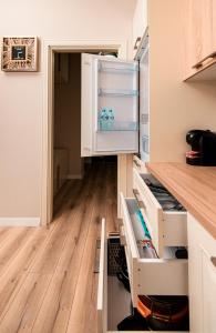 都拉斯Loris Apartaments 205的厨房铺有木地板,配有开放式冰箱。