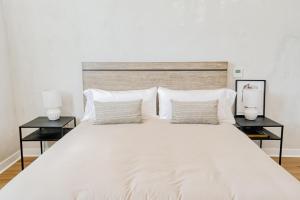圣巴巴拉Villa Castillo 3的一间卧室配有一张带两盏灯的大型白色床。