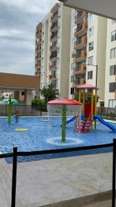 里考尔特Apartamento Girardot Peñalisa con Piscina的一座大楼内带游乐场的游泳池