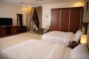 阿尔阿尔فندق هلا اثنين的酒店客房设有两张床和一台平面电视。