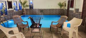 乌代浦Hotel Ushaan Haveli的一组椅子坐在游泳池旁