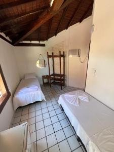 阿拉亚尔达茹达Novos Baianos Hostel e Pousada的一间设有两张床和椅子的房间