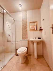 邦比尼亚斯Vila Madu的浴室配有卫生间、盥洗盆和淋浴。