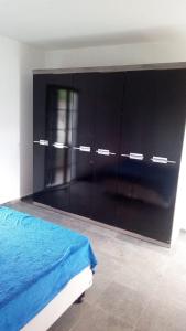 坎皮纳斯Hostel família Campineira的一间卧室配有床和大型黑色橱柜