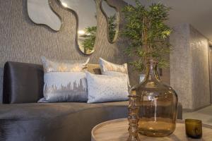 麦德林Luxury Suites Prana By Cadissa的带沙发的客厅和一张桌子上的玻璃瓶