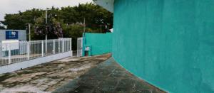 坎皮纳斯Hostel família Campineira的一座带绿色墙壁和围栏的建筑