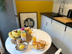 迈松拉菲特Appart' Studio cooconing - Champs Elysées - JO 2024的一张桌子,上面放着一盘早餐食品和橙汁