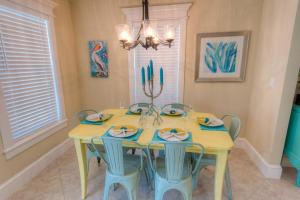 霍姆斯海滩Key Lime Cottage的用餐室配有黄色的桌子和椅子