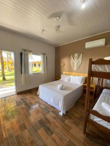 普拉杜Quintal da Praia的卧室配有白色的床和窗户。