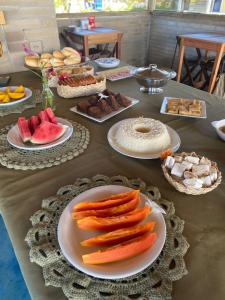 普拉杜Quintal da Praia的餐桌上放有食物和水果盘的桌子