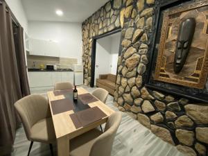 帕莱索海滩Paraiso villas的用餐室设有石墙、桌子和椅子